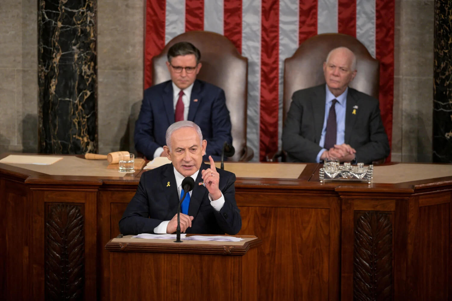 In the background, House Speaker Mike Johnson (left) and Senate Foreign Relations Chair, Sen. Ben Cardin (right), take in Israeli Prime Minister Benjamin Netanyahu's speech to a joint meeting of Congress at the U.S. Capitol.