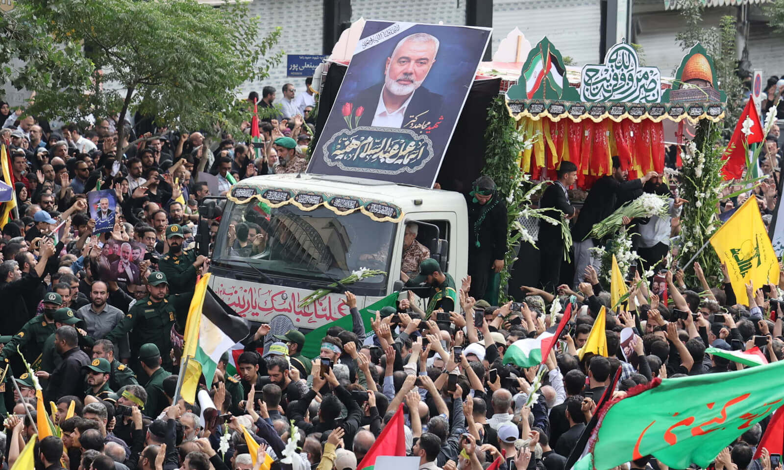 Mourners congregate around a vehicle transporting the coffins of Ismail Haniyeh and his bodyguard.