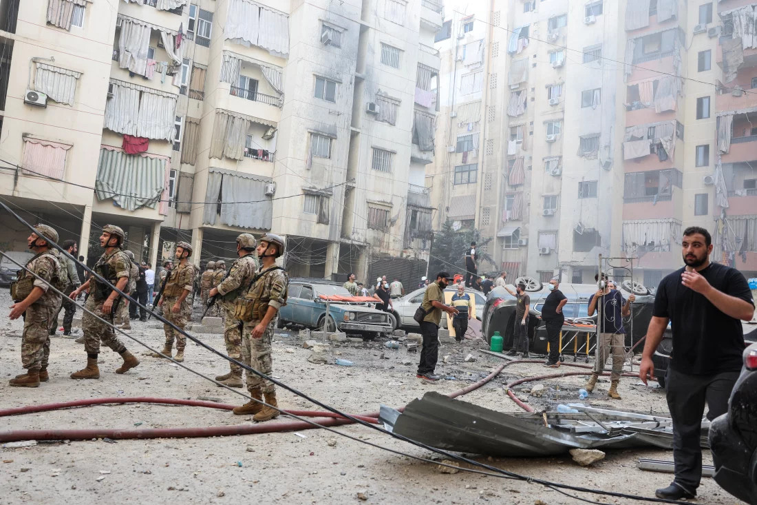 People and members of the military inspect the site of an Israeli strike in the southern suburbs of Beirut, Lebanon, on Friday.