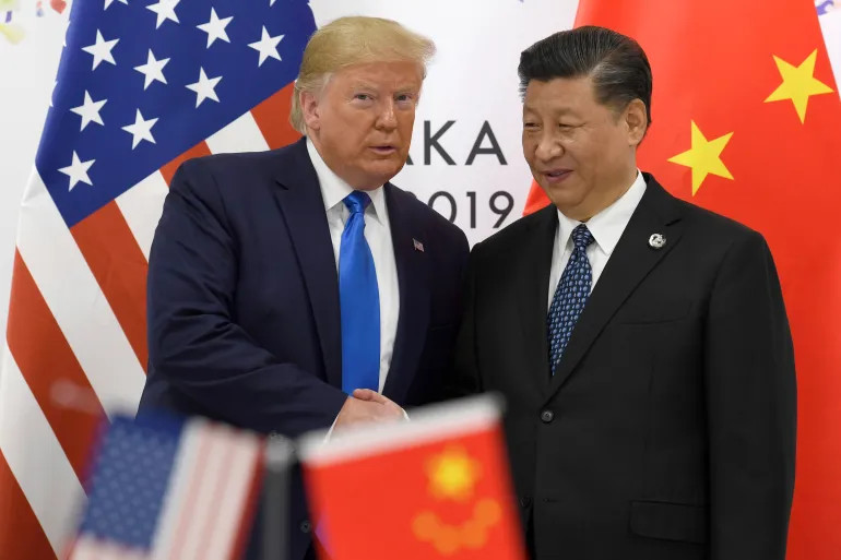 Then-US President Donald Trump poses for a photo with Chinese President Xi Jinping during a meeting on the sidelines of the G20 summit in Osaka, Japan, June 29, 2019 [Susan Walsh/AP Photo]